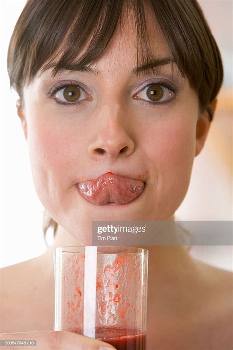 Young Woman Drinking Fruit Smoothie Licking Lip With Tongue Closeup