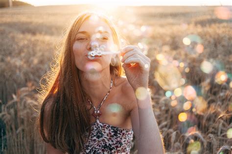 Woman Blowing Bubbles On Summer Nature On Sunset By Stocksy