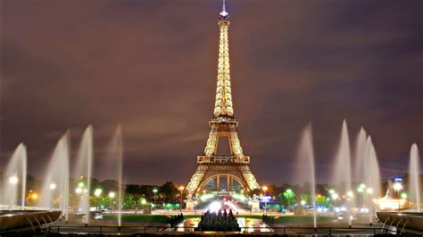 Paris Eiffel Tower With Water Fountain On Sides With Clouds Background