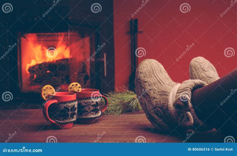 Feet In Woollen Socks By The Christmas Fireplace Woman Relaxes Stock