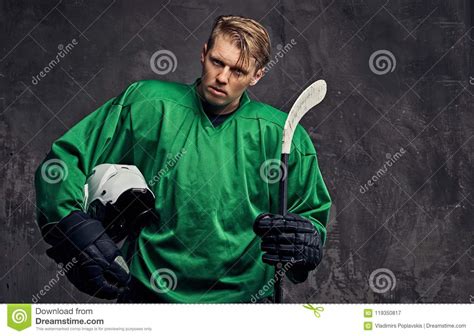 Tired Professional Hockey Player In A Green Sportswear Holds A Hockey