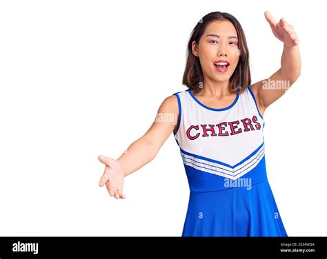 Young Beautiful Chinese Girl Wearing Cheerleader Uniform Looking At The