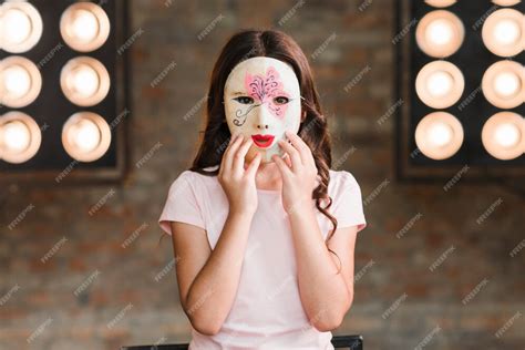 Premium Photo Girl Wearing Mask Standing Against Stage Light