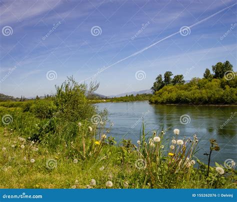 Summer Cloud Trails Over The Skagit River In Washington With Lush
