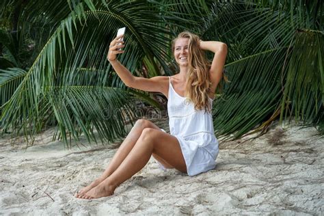 The Young Girl With A Fair Hair Takes A Selfie Being In The Tropical