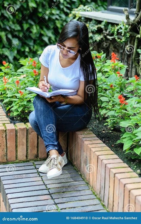 Belle Femme Colombienne Avec Des Lunettes De Soleil Assis Sur Un Banc De Jardin écrivant Dans