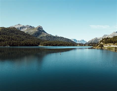 Lake Surrounded By Mountains Under Blue Sky · Free Stock Photo