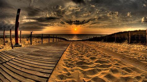 Sand And Pathway To Sea Under Cloudy Sky And Sunset During Evening