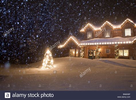 Log Home Decorated With Christmas Lights With Snow Falling