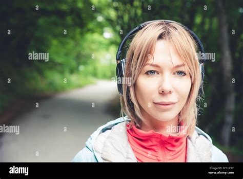 Attractive Blond Woman In The Forest Close Up Portrait Of A Sporty Smiling Girl Listening To