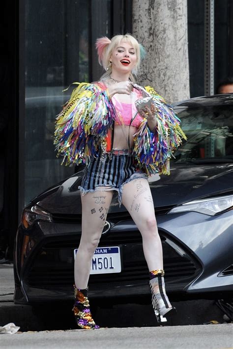 A Woman Dressed In Colorful Clothing Standing Next To A Car