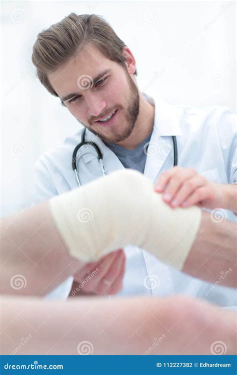 Closeup Of A Doctor Examining Injured Leg Of The Patient Stock Photo