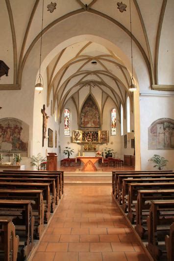 Blick vom altar aus richtung orgel und der empore mit neun heligenbildern. Kirche innen | Franziskanerpfarre Lienz