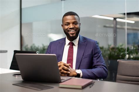 Cheerful Black Businessman Posing At Workdesk In Office Stock Photo By