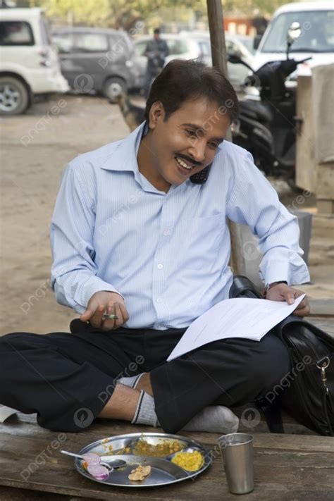 Salesman Talking On A Mobile Phone And Smiling Holding Papers Photo