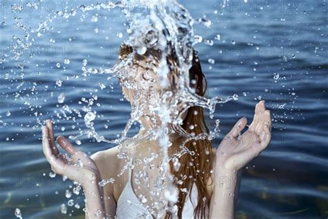 Caucasian Woman Splashing In Ocean Photo12 Tetra Images Dmitry Ageev