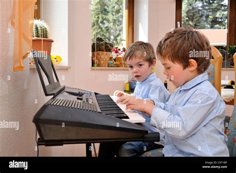 Twin Boys 4 Playing Music Together On A Keyboard Stock Photo Alamy