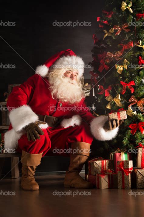 Santa Putting Gifts Under Christmas Tree In Dark Room Stock Photo By Hasloo