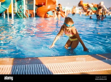 Fröhliches Mädchen In Einem Hellen Badeanzug Und Blau Schwimmen Schutzbrille Dreht Sich In Einem