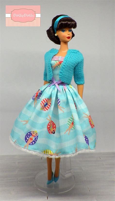 a doll is wearing a blue dress and cardigan
