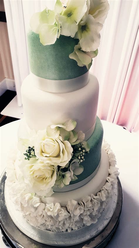Four Tier Fondant Covered Wedding Cake Decorated With A Collection Of