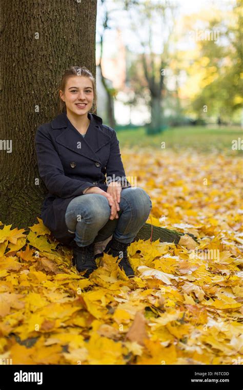 Young Girl Sitting In Autumn Park Stock Photo Alamy