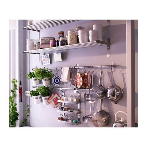 Pots And Pans Are Hanging On The Wall Next To Shelves With Kitchen Utensils