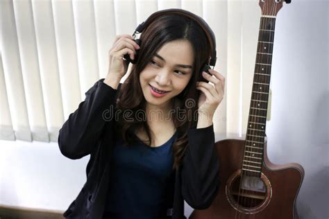 Pretty Beautiful Asian Woman Wearing Headphone And Listening Music