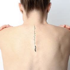 Tatuaje en la espalda que dice en latín alis volat propriis que significa vuela con sus