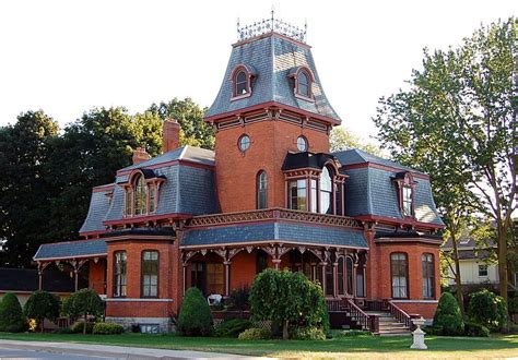 A Large Red Brick House With A Steeple On The Top And Two Story Windows