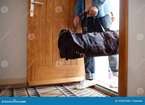 Midsection Of Young Man With Bag Entering Front Door When Coming Back