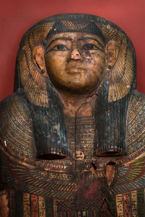 An Egyptian Statue Is Shown Against A Red Wall