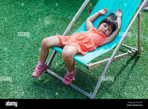 A Black Haired Girl Lying On A Lounger In The Garden In Summer Stock