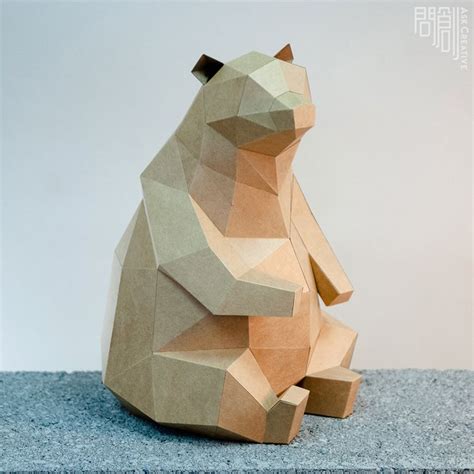 A Paper Sculpture Of A Bear Sitting On The Ground