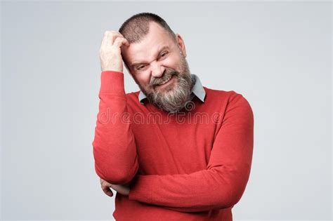 Confused Man With Beard Scratching Head Looking At Camera Stock Photo