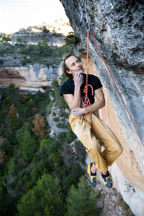 Outdoor Sport Rock Climber Dangles In Midair As He Struggles To Climb