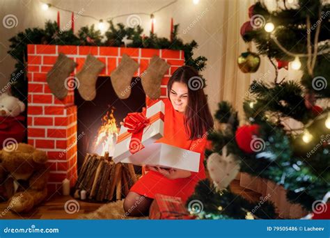 The Beautiful Christmas Girl In Red Dress Near The Fireplace T Stock