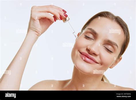 Portrait Of Young Beautiful Girl With Clear Face Applying Face Serum Taking Care After Skin