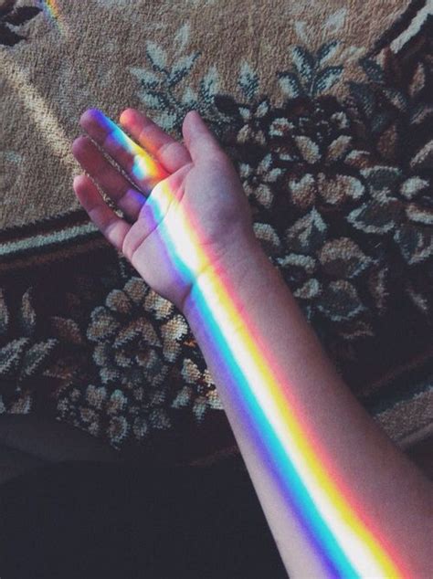 A Person Holding Their Hand Out With A Rainbow Painted On The Side Of
