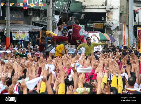 devotees raise their hands as the black nazarene replica makes its way through quezon boulevard