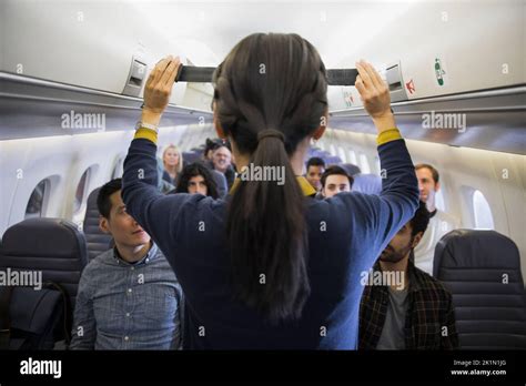 Female Flight Attendant Demonstrating Seat Belt Safety In Airplane