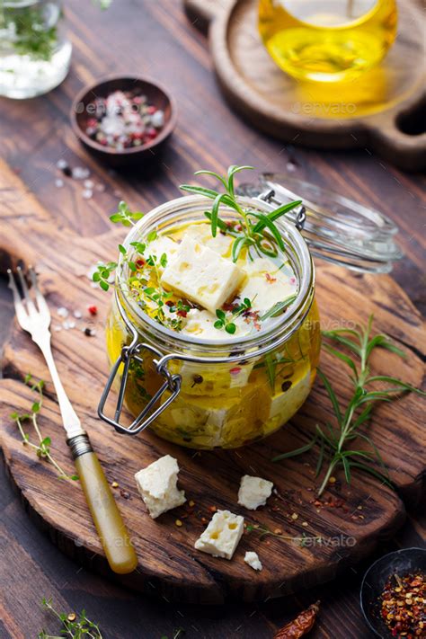 Feta Cheese Marinated In Olive Oil With Fresh Herbs In Glass Jar