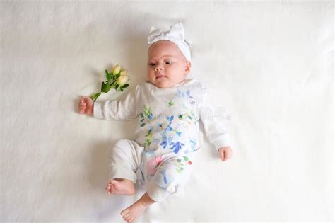 Beautiful Baby Girl Holding A Flower On White Blanket Stock Image