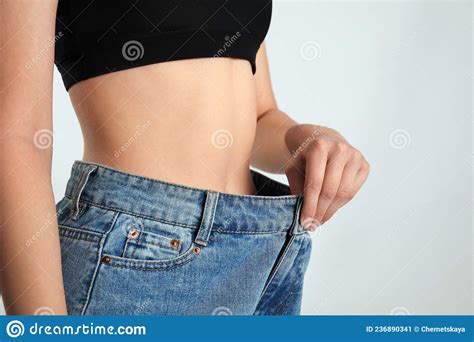 Mulher Magra Em Jeans Sobredimensionados No Fundo Leve Conceito De Perda De Peso Imagem De