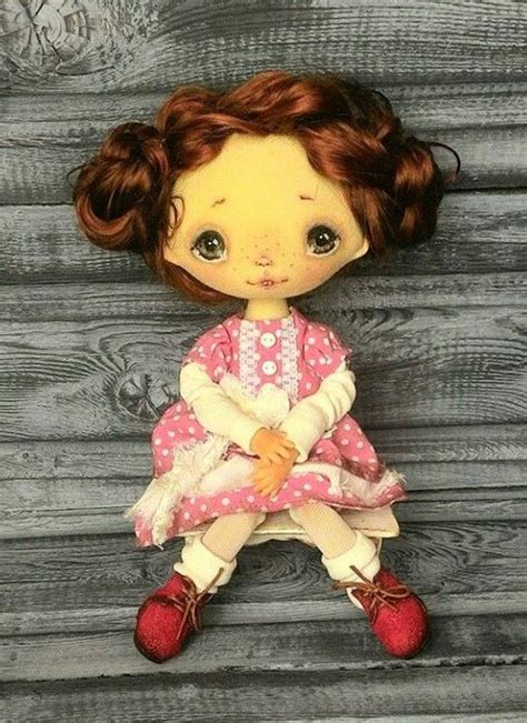 A Small Doll Sitting On Top Of A Wooden Floor Next To A Wall With Wood