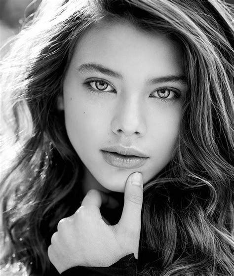 A Woman With Long Hair Posing For A Black And White Photo Her Hand On Her Chin