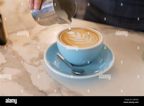 Hand Of Barista Making Froth Art In Coffee Cup Stock Photo Alamy