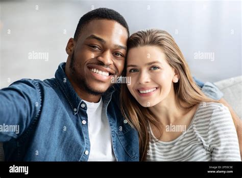 Happy Interracial Couple Taking Selfie Together At Home Stock Photo Alamy