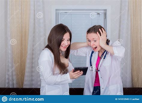 Dos Doctores O Enfermeras De Sexo Femenino Miran La Tableta Se Choca O Muy Se Sorprende Una