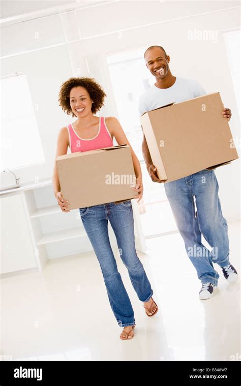 Couple With Boxes Moving Into New Home Smiling Stock Photo Alamy